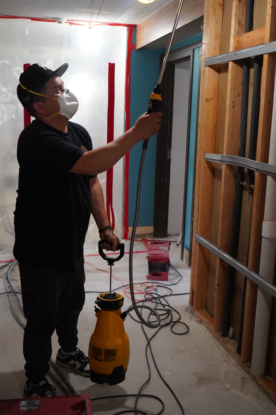 Technician spraying antimicrobial on stripped walls